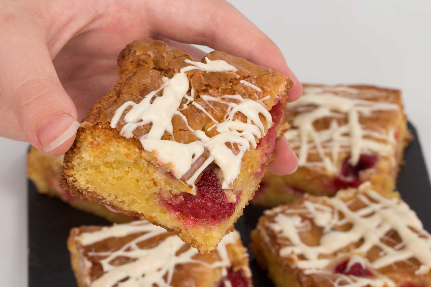 Raspberry-Blondie-slice-held-RoseHartSweets